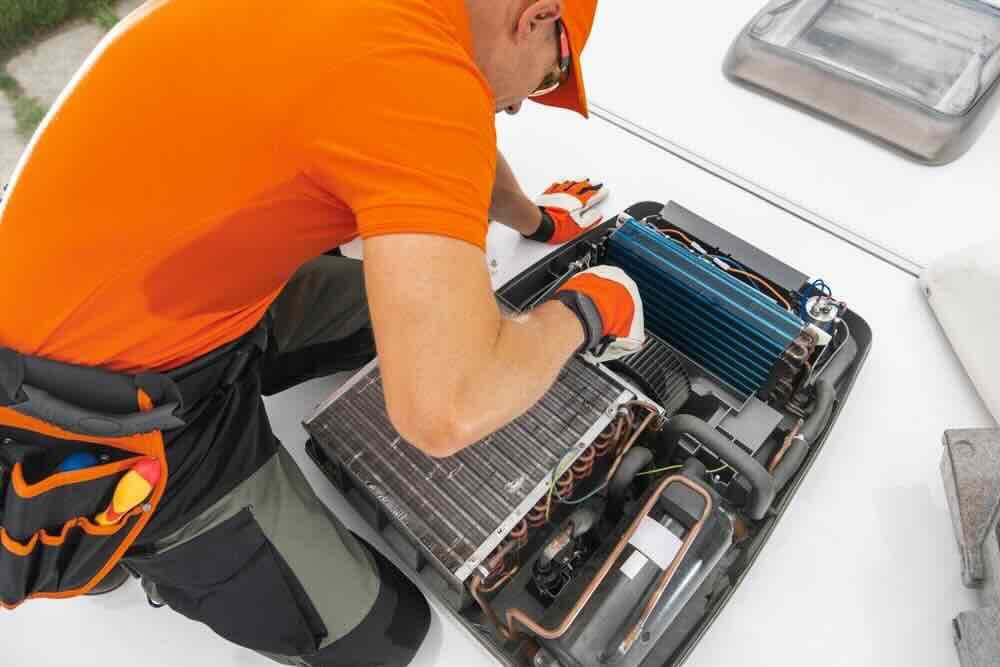 Certified RV technician repairing camper appliances and HVAC systems